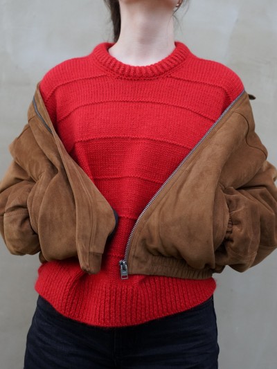 Close-up of the Ruke Scarlet sweater knitting pattern worn under a brown jacket.