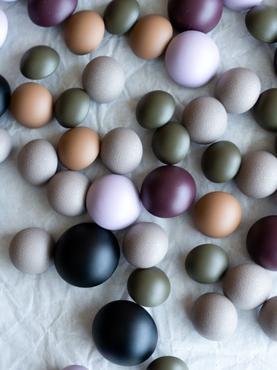 Top view of domed metal buttons in lavender, plum, olive, sand, stone beige and matte black