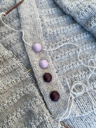 Lavender mist and plum wine matte metal buttons on a grey hand knitted cardigan