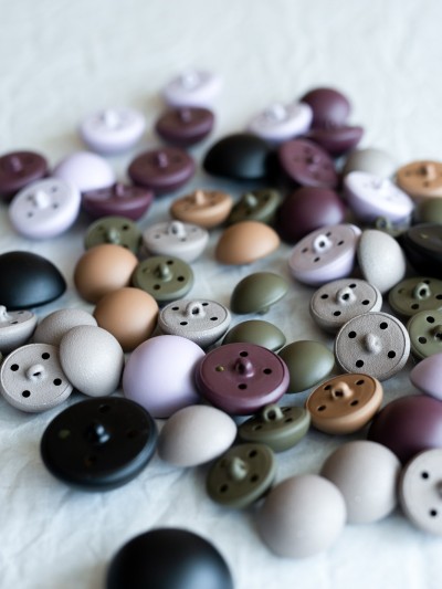 Assorted matte metal shank-back buttons in multiple colours shown in a flat lay