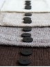 Ruke black 28 mm four-hole bioresin buttons on neutral knitted swatches