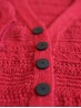 Ruke black 28 mm four-hole bioresin buttons on a red knit cardigan detail