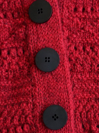 Ruke black 28 mm four-hole bioresin buttons on a red knitted cardigan