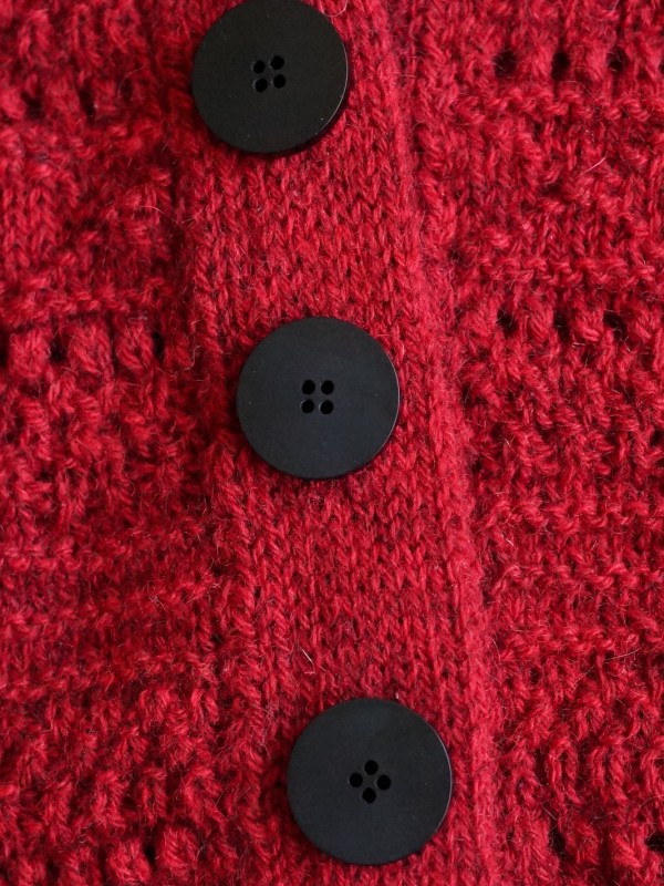 Ruke black 28 mm four-hole bioresin buttons on a red knitted cardigan
