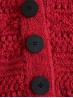 Ruke black 28 mm four-hole bioresin buttons on a red knitted cardigan