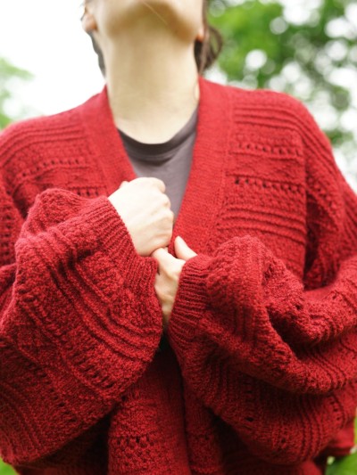 Close-up of the red Ruke Moon cardigan knitting pattern front texture and sleeves