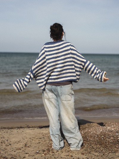 Marine sweater knitting pattern by Ruke Knit - oversized striped sweater back view on the beach