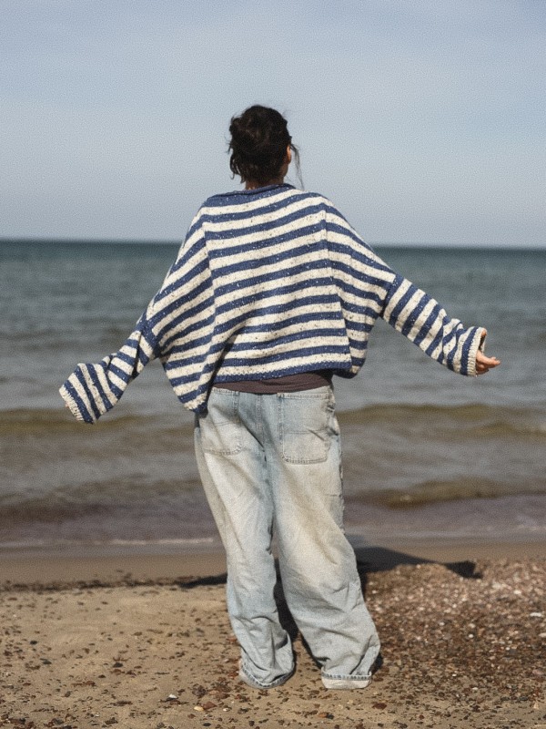 Marine sweater knitting pattern by Ruke Knit - oversized striped sweater back view on the beach