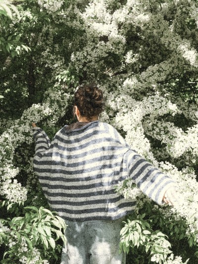 Marine sweater knitting pattern by Ruke Knit - oversized striped sweater back view near flowers