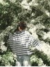 Marine sweater knitting pattern by Ruke Knit - oversized striped sweater back view near flowers